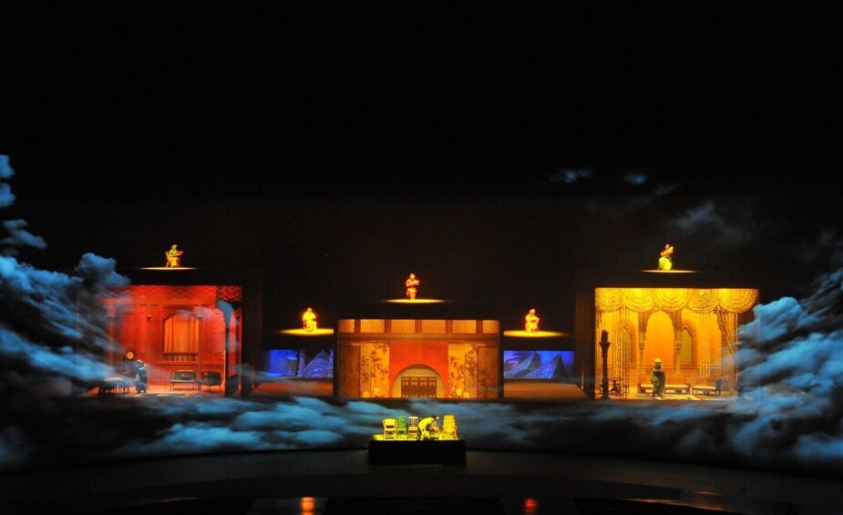 A nighttime scene with illuminated buildings and statues, surrounded by clouds. 5