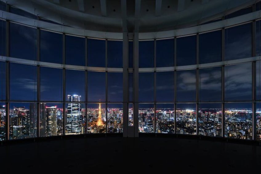 A panoramic view of a cityscape at night from a high-rise building with large windows. 4