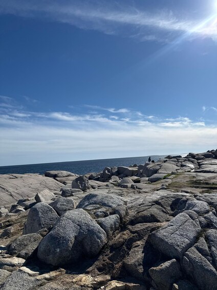 A rocky coastline with large boulders and a clear blue sky. 3