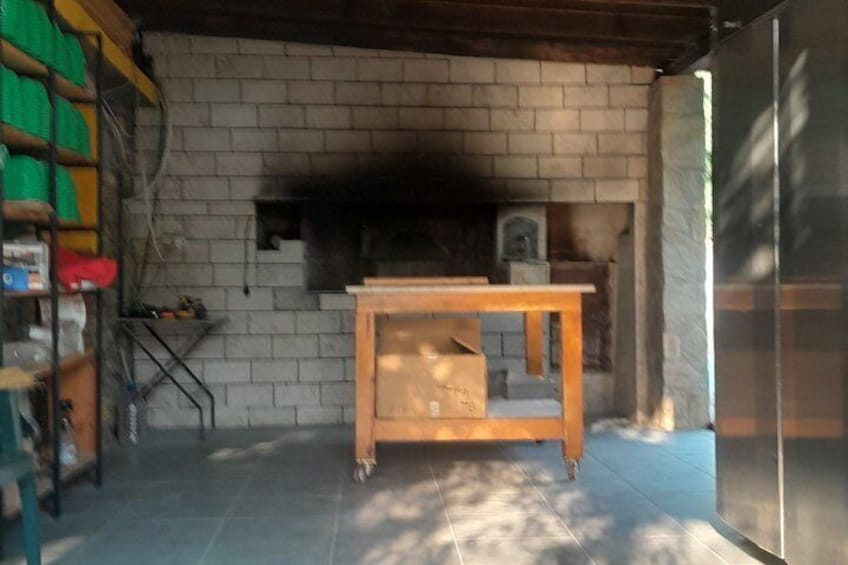 A brick fireplace with a wooden table in front, a ladder, and a green shelf with items on the left. 4