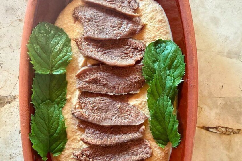 Sliced meat on a flat surface with green leaves. 2