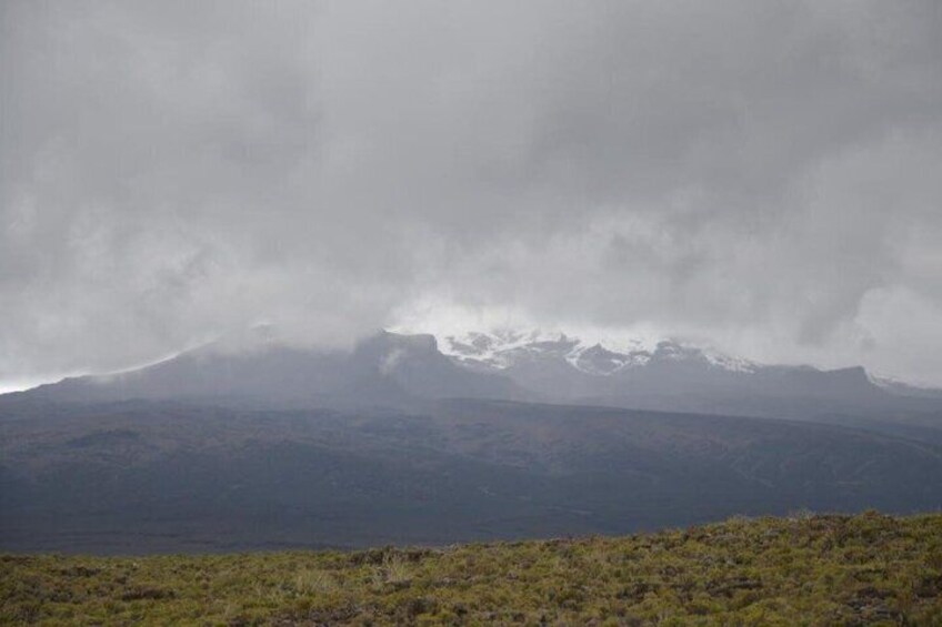 A mountain range with snow-capped peaks and a cloudy sky. 1