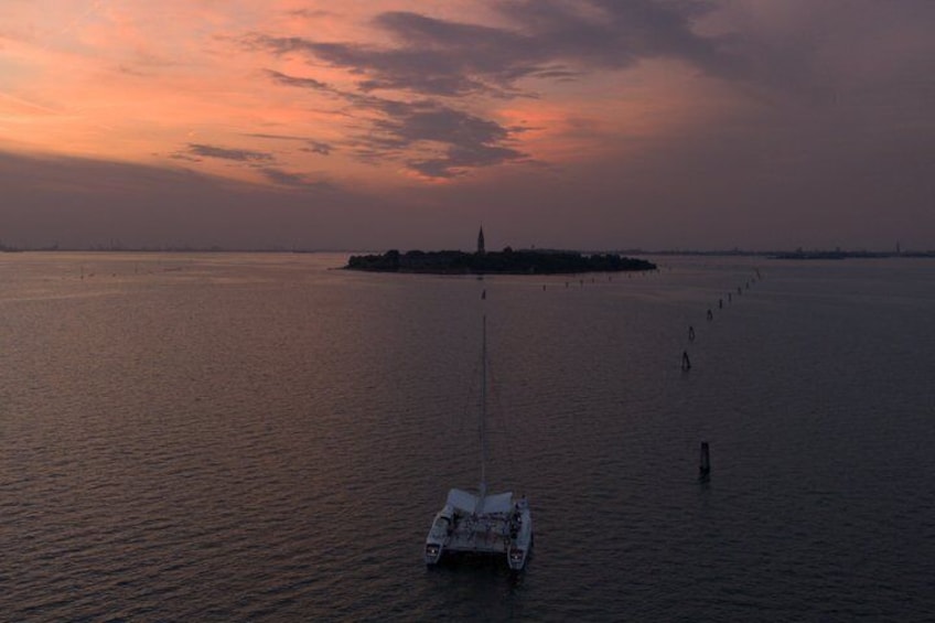 A sailboat on calm water with a sunset in the background. 2