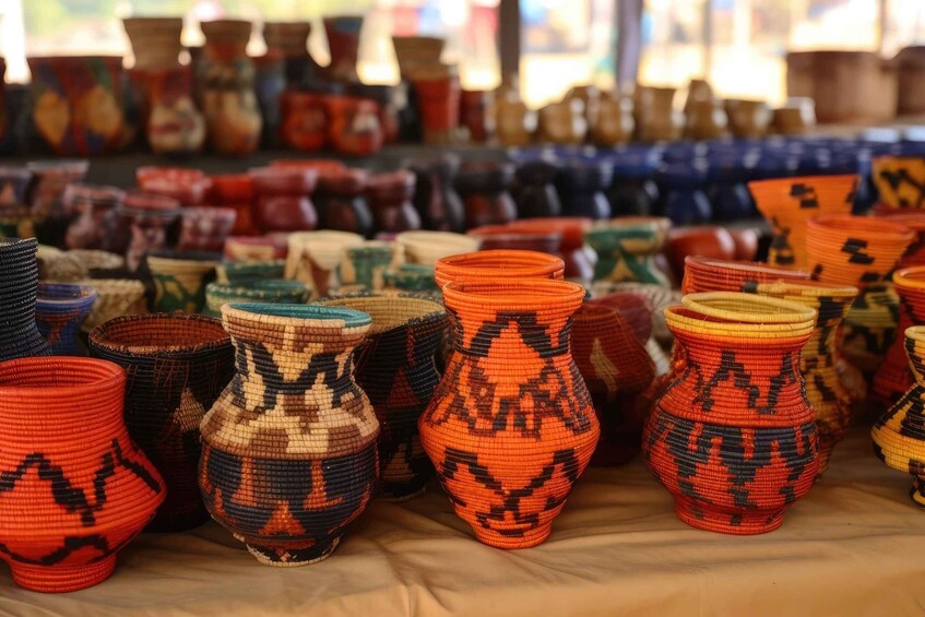 A variety of colorful woven baskets and pottery displayed for sale. 2