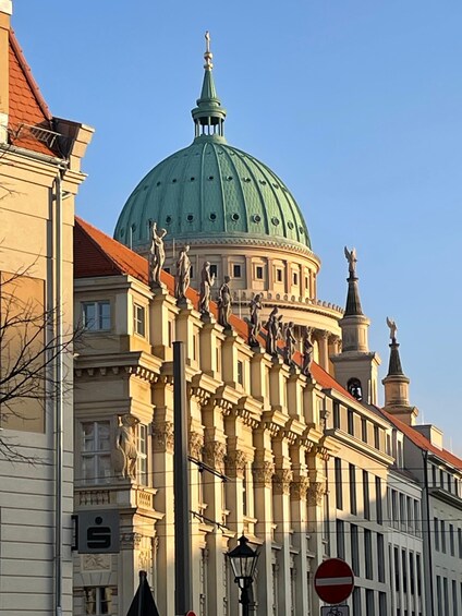 A historic building with a large green dome, ornate statues, and classical architecture. 5