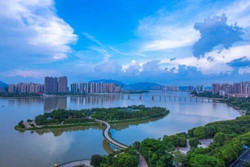 A river with a bridge, a park with trees, and high-rise buildings in the background. 5
