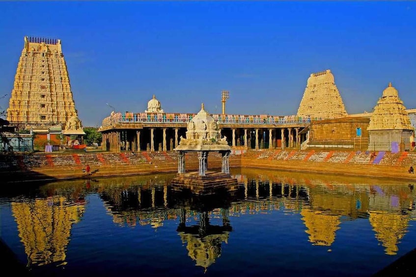 A temple complex with a central water body reflecting the structures. 4