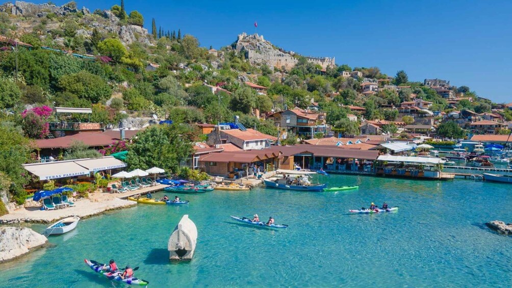 A coastal town with clear blue waters, boats, and a historic castle on a hill. 3