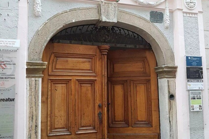 A large wooden double door with an arched entrance, surrounded by stone columns and decorative moldings. 5
