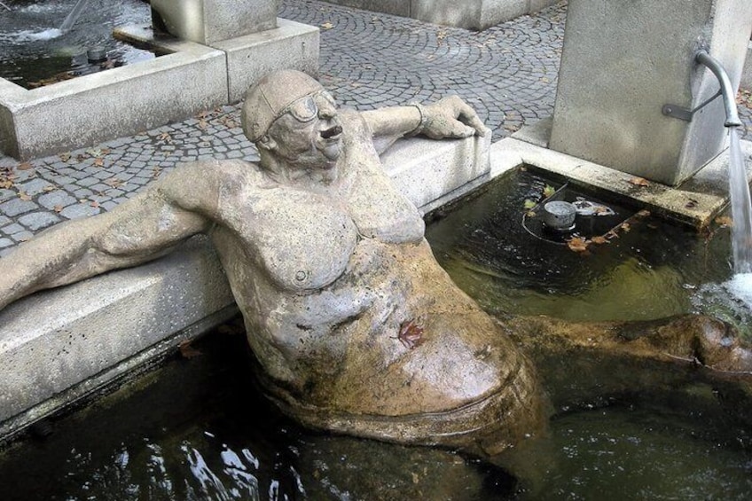 A weathered statue of a woman in a fountain. 3