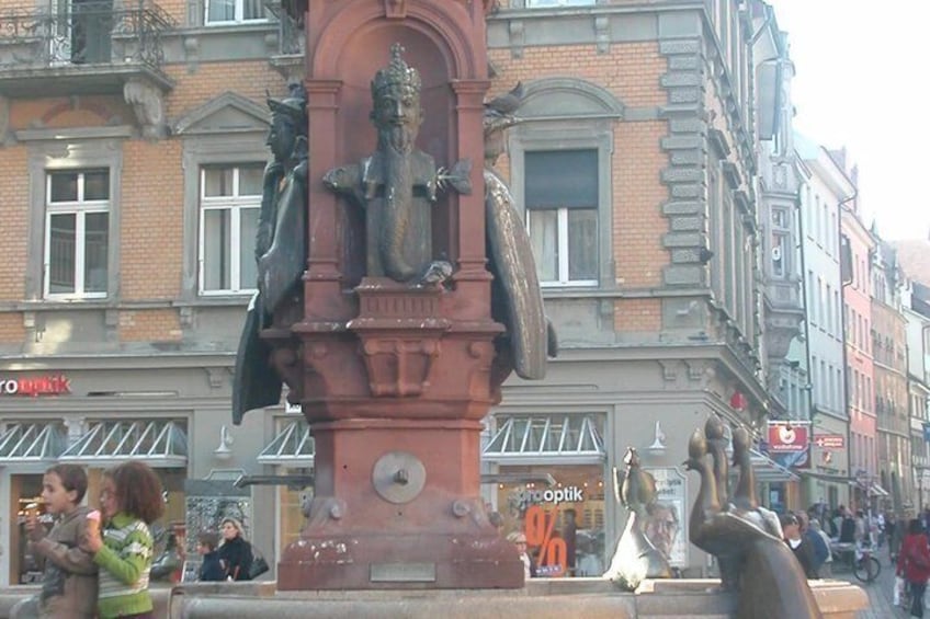 A statue in a public square with buildings in the background. 4