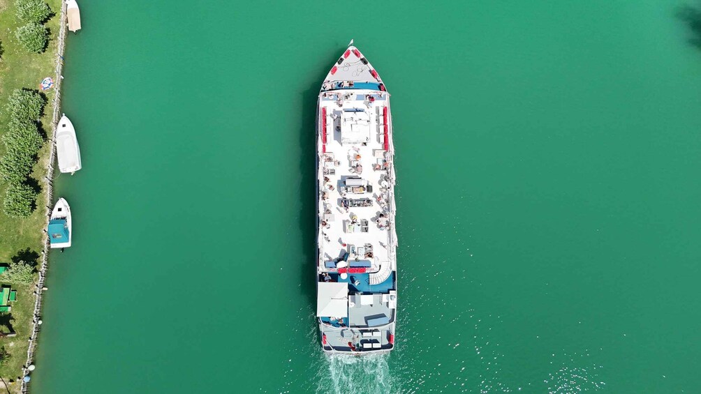 A large cruise ship docked at a pier with a calm greenish water body. 2