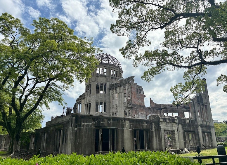 An ancient, partially ruined temple with a large central dome, surrounded by lush greenery and trees. 5