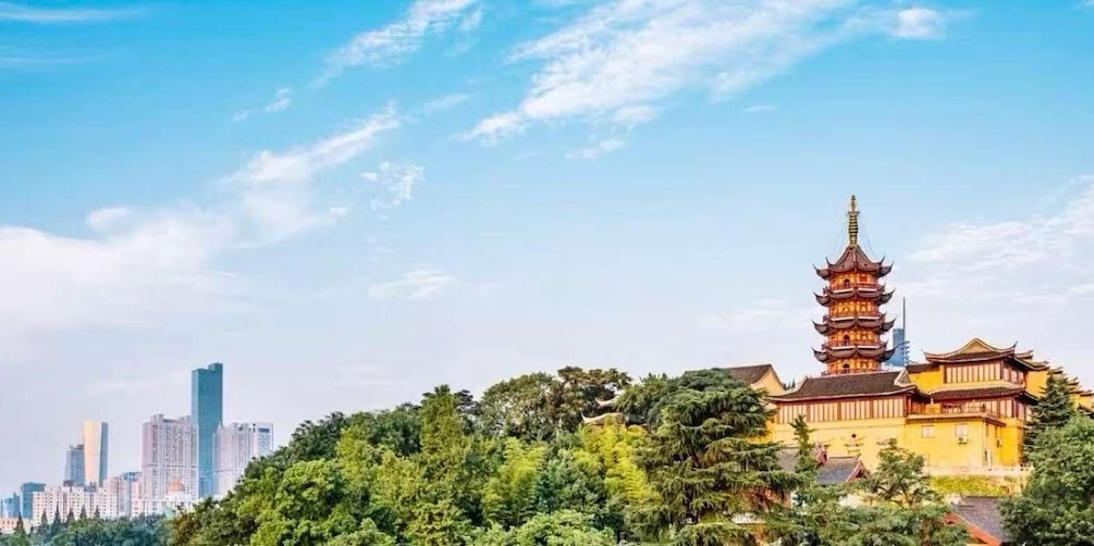 A traditional pagoda with multiple tiers, surrounded by lush greenery and modern buildings in the background. 3