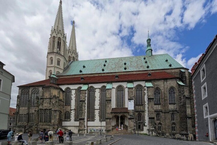 A historic church with a tall spire and a green roof. 3
