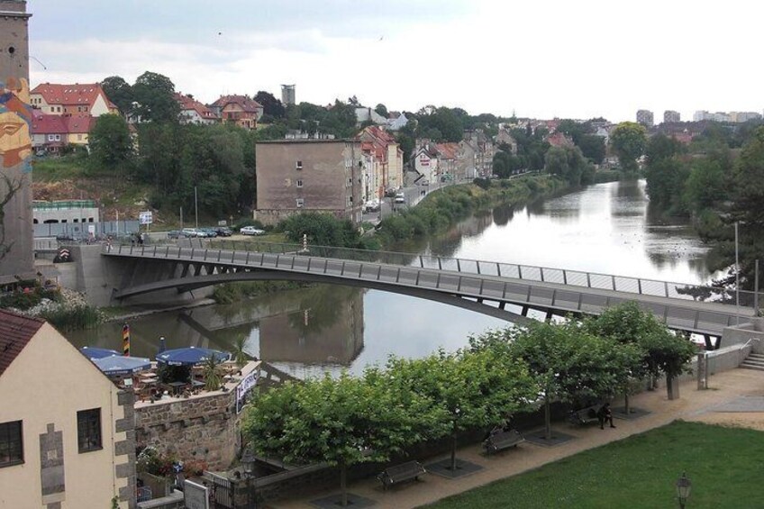 A river with a bridge, buildings, and a grassy area with trees. 2