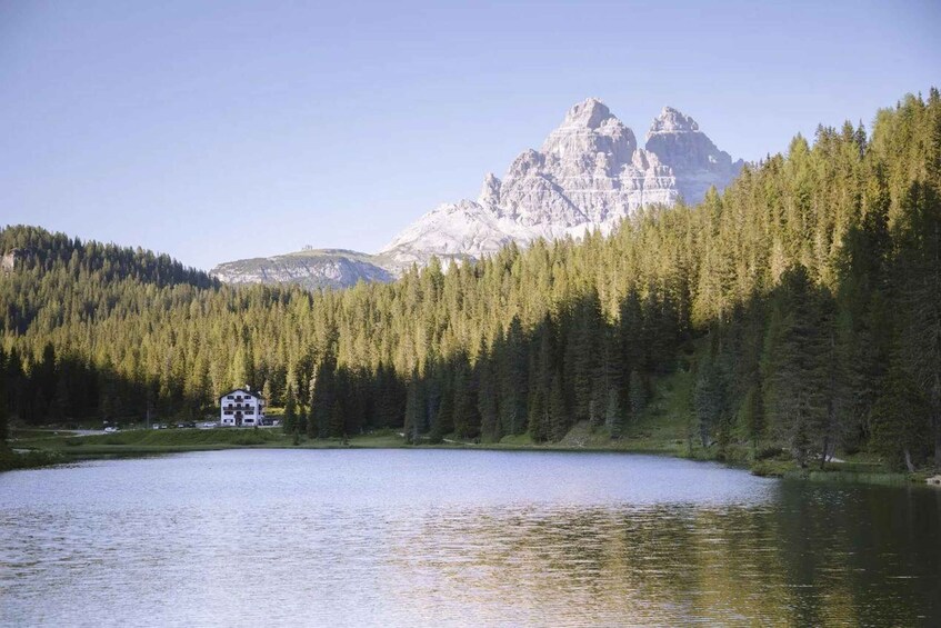 A lake surrounded by dense forest and a mountain range. 4