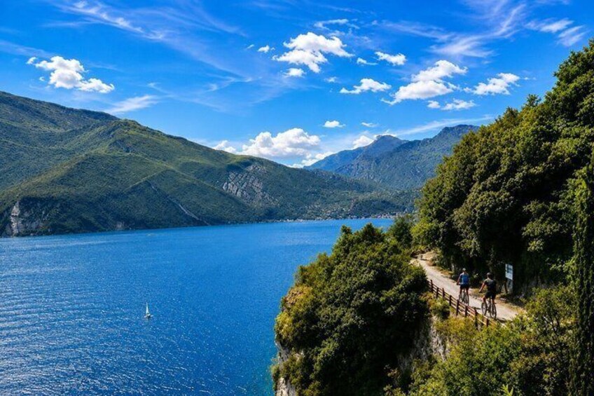 A lake surrounded by mountains, a clear sky, and a wooden pathway. 3
