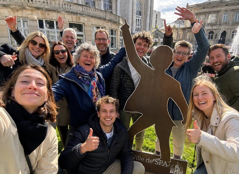 A group of people posing with a cutout of a person and the text 'Ville de Spa'. 3