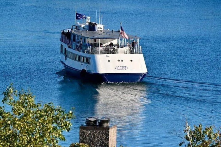 A large white and blue ferry with American flags, moving through calm blue water. 5