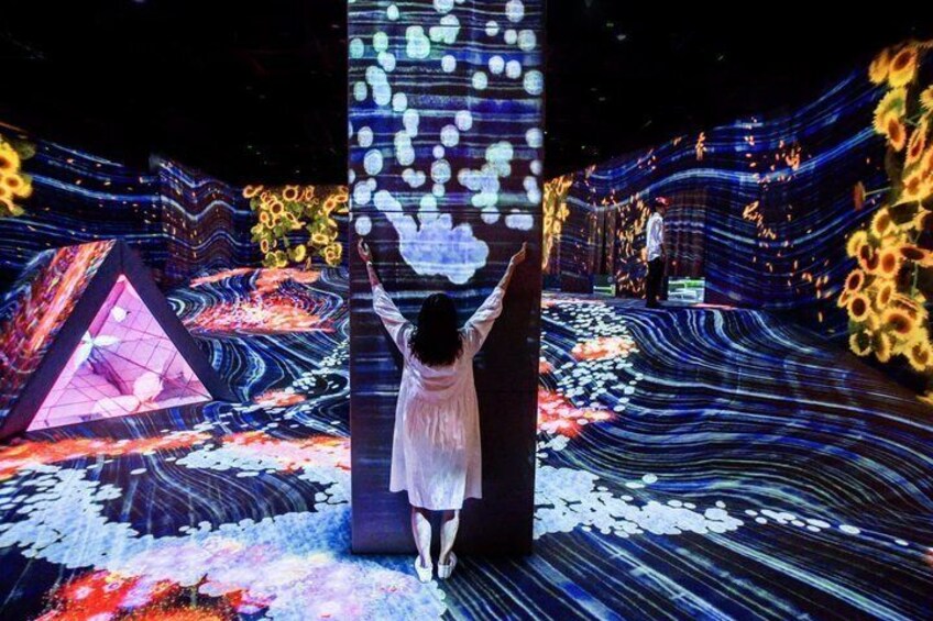 A person standing in front of a large, illuminated column with a digital display. 3