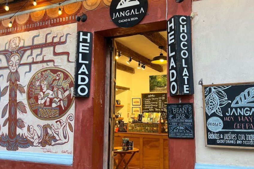 A storefront with a mural, signs for 'Jangala' and 'Helado', and a menu board. 2