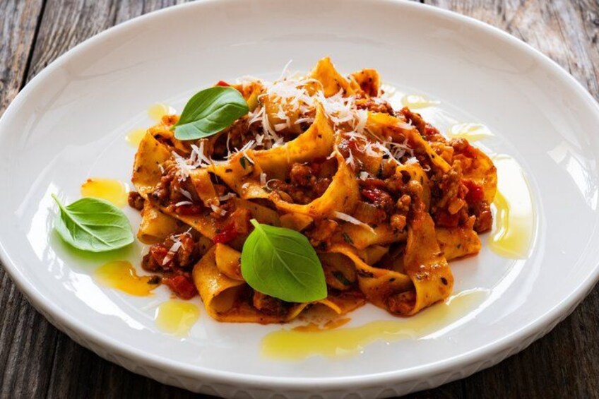 A plate of pasta with tomato sauce, cheese, and basil leaves. 2