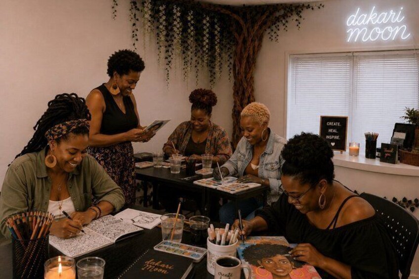 A group of people engaged in a drawing activity at a table with art supplies. 2