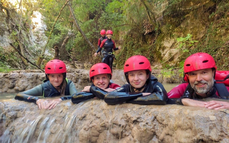 Four people in a river rafting activity, wearing helmets and life jackets. 2