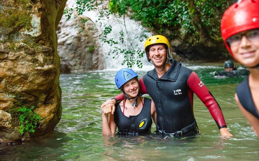 Two people in a river wearing helmets and wetsuits. 5