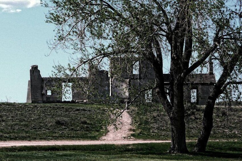 A historical building with ruins, a tree in the foreground, and a clear sky. 3