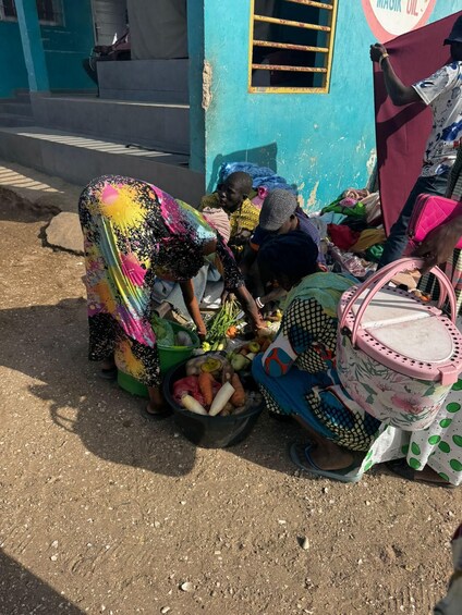 Two women sorting vegetables at a roadside stall. 2