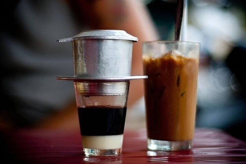 Two drinks, one with a metal strainer and one with a straw, on a wooden table. 3