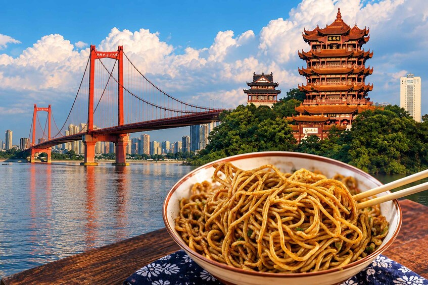 A bowl of noodles, a red bridge, and traditional Chinese architecture. 1