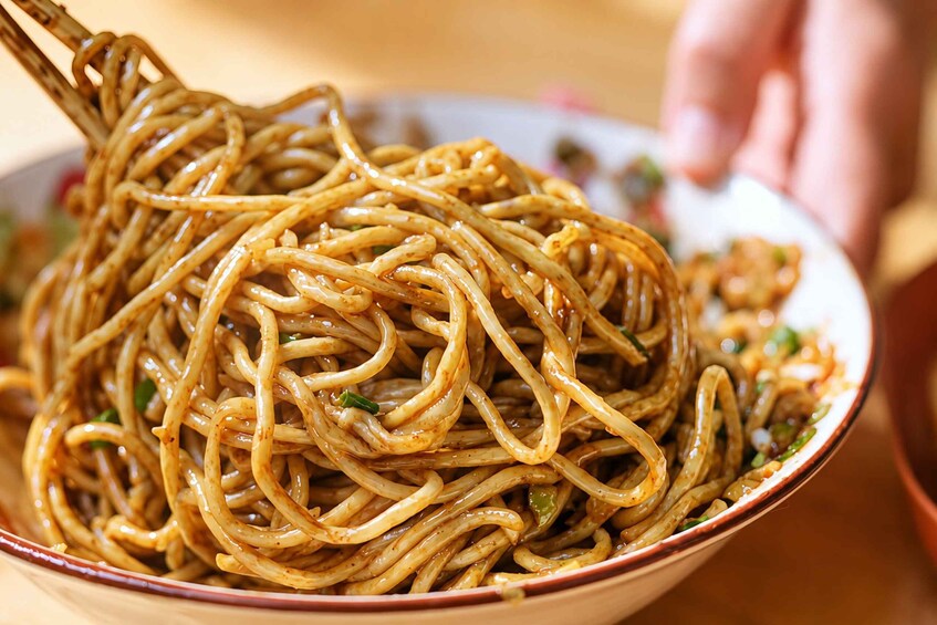 A bowl of noodles with chopsticks. 3