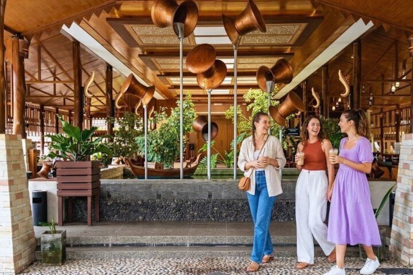 An outdoor wooden structure with hanging copper pots, potted plants, and a stone pathway. 3