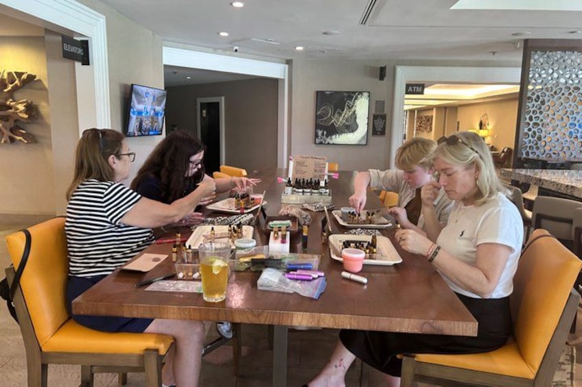 A group of people sitting at a wooden table with food and drinks, in a room with a modern interior design. 3