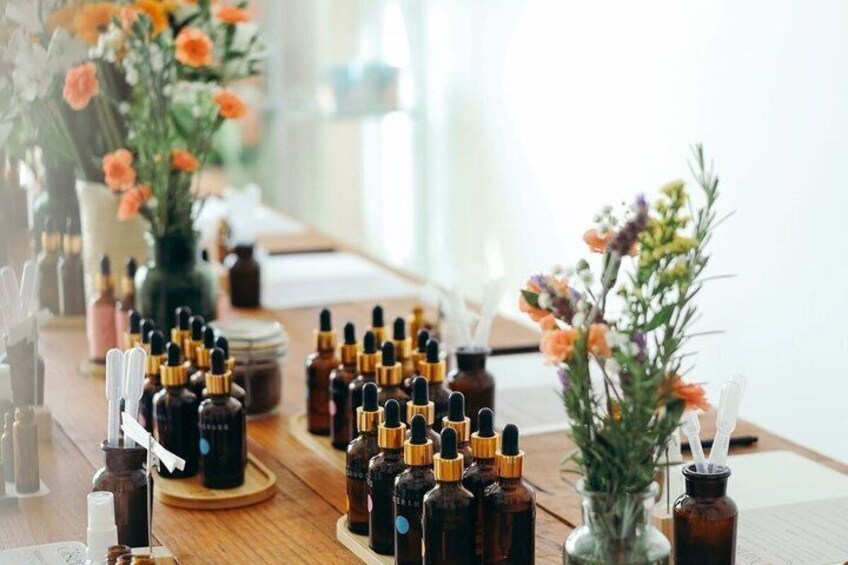 A table with multiple bottles of liquid, likely perfumes or essential oils, arranged neatly. 4