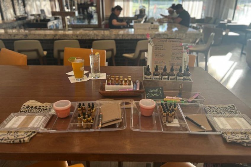 A table with a drink, a menu, and various small bottles. 2