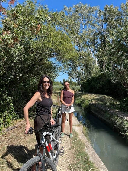 Two people standing by a canal with a bicycle. 2