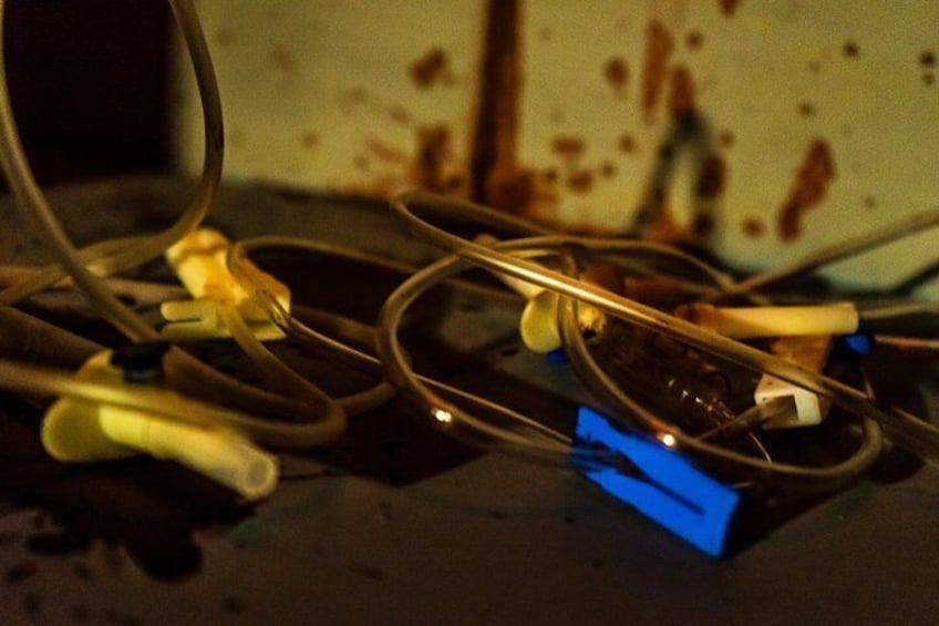 Tangled electrical cords and exposed wires on a dark surface. 5