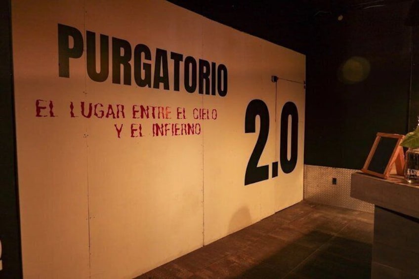 A wall with the text 'PURGATORIO El Lugar Entre El Cielo Y El Infierno 2.0' and a large number '2.0'. 1