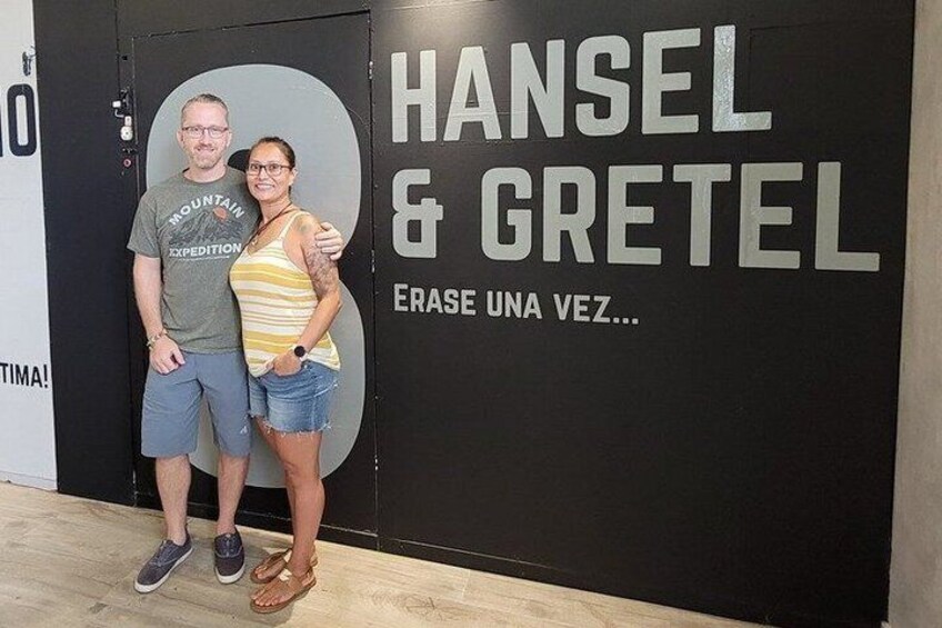 Two people standing in front of a wall with text. 3