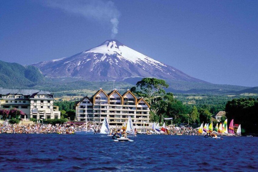 A coastal town with a prominent mountain in the background, a marina with boats, and colorful buildings. 4