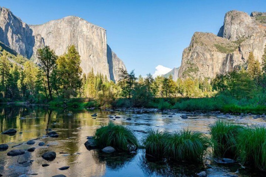 A river with rocks, trees, and mountains in the background. 2