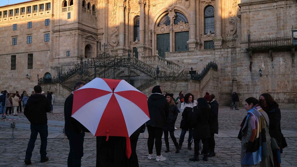 A group of people walking in front of a historic building with ornate architecture. 3