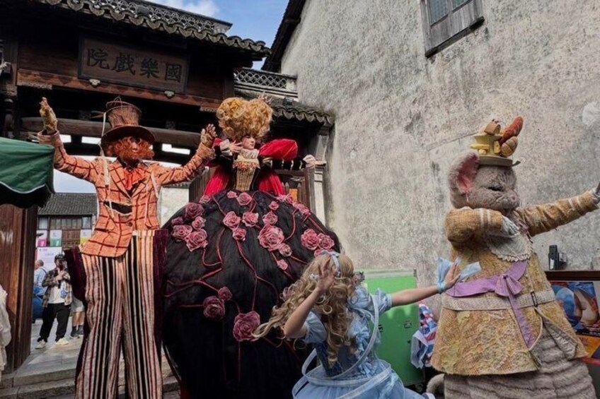 A street parade with performers in costumes, a building with traditional architecture, and a crowd of spectators. 4