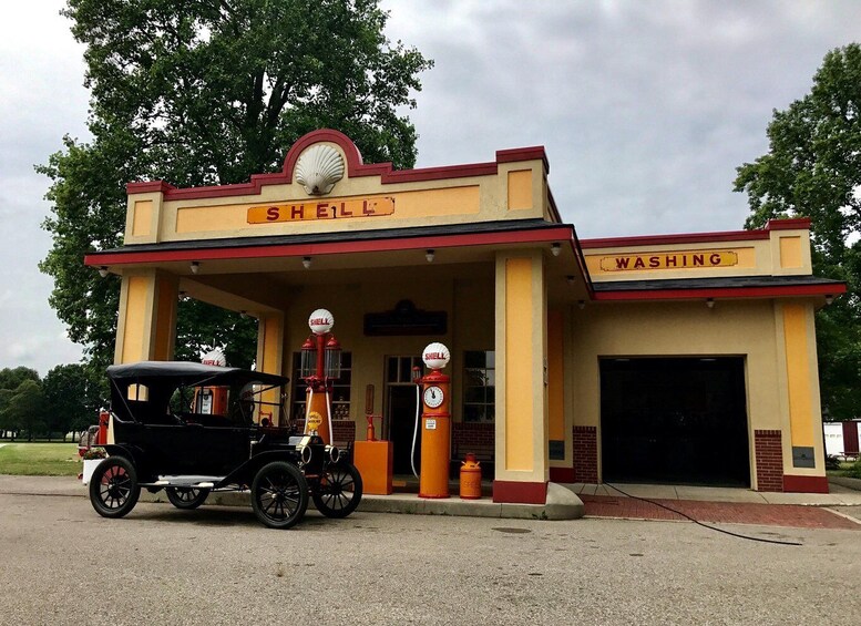A vintage Shell gas station with a classic car parked in front. 2