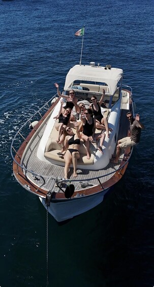 A small boat with people on board, anchored in the water. 5