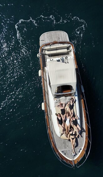 A boat with a wooden deck and white canopy, floating on dark blue water. 3